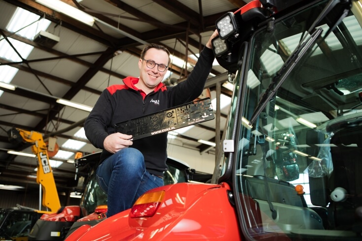 Man werkt aan landbouwmachine in werkplaats.