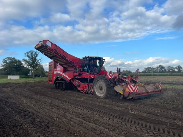 Rode landbouwmachine aan het werk op veld