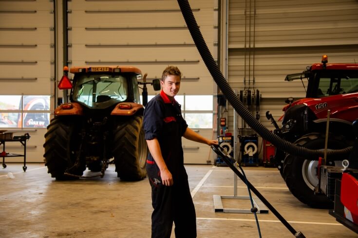 Monteur werkt in tractorwerkplaats