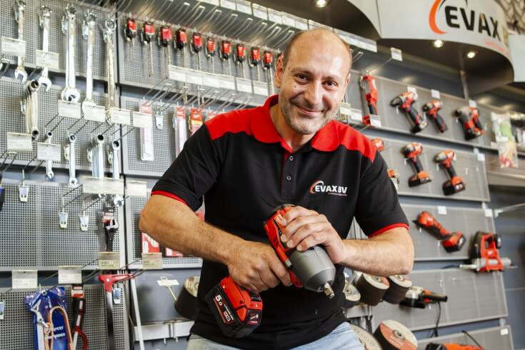 Man met elektrische schroevendraaier in gereedschapswinkel.