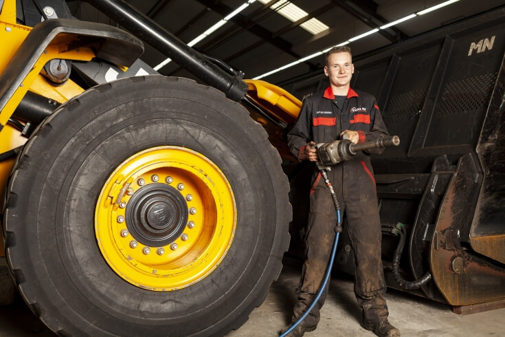 Monteur repareert machinewiel in werkplaats.