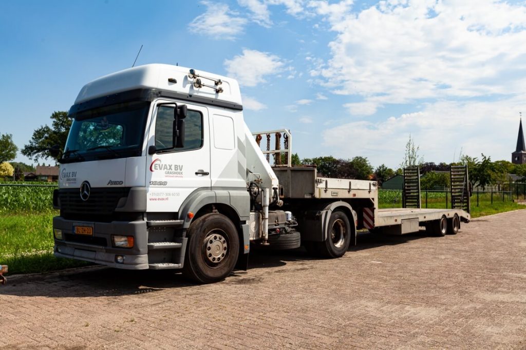 Vrachtwagen met oplegger op een zonnige weg