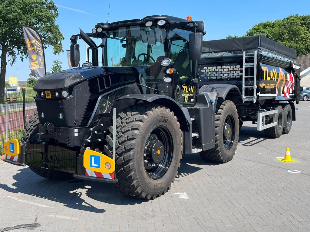 Zwarte tractor met aanhanger op parkeerplaats